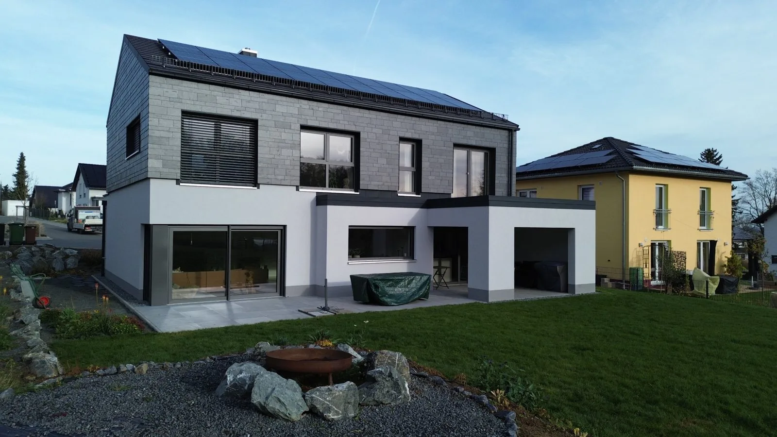 Haus Noah: Einfamilienhaus mit Schieferfassade im Obergeschoss, Photovoltaik und Terrasse