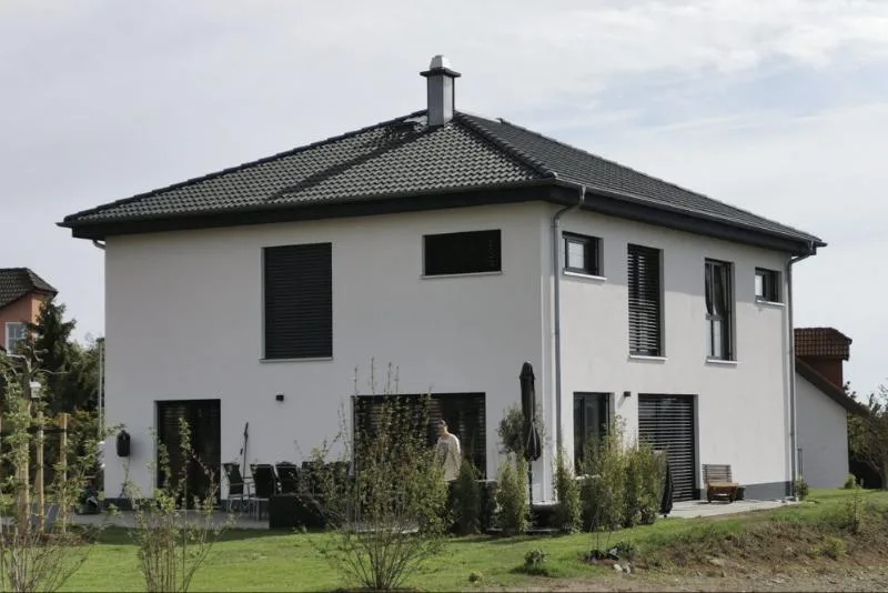 Haus Alex: Weiße Stadtvilla mit Walmdach und Terrasse im Garten