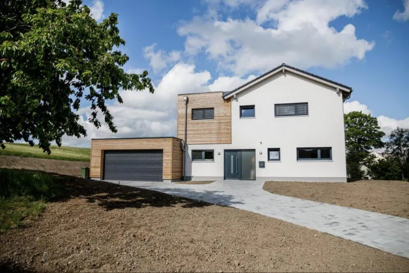 Haus Felix: Einfamilienhaus mit Holzverkleidung an Garage und Erker