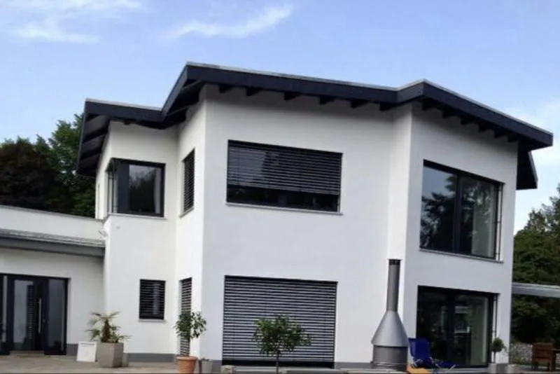 Haus Angela: Weiße Villa mit flach geneigtem Dach und großen Fensterflächen