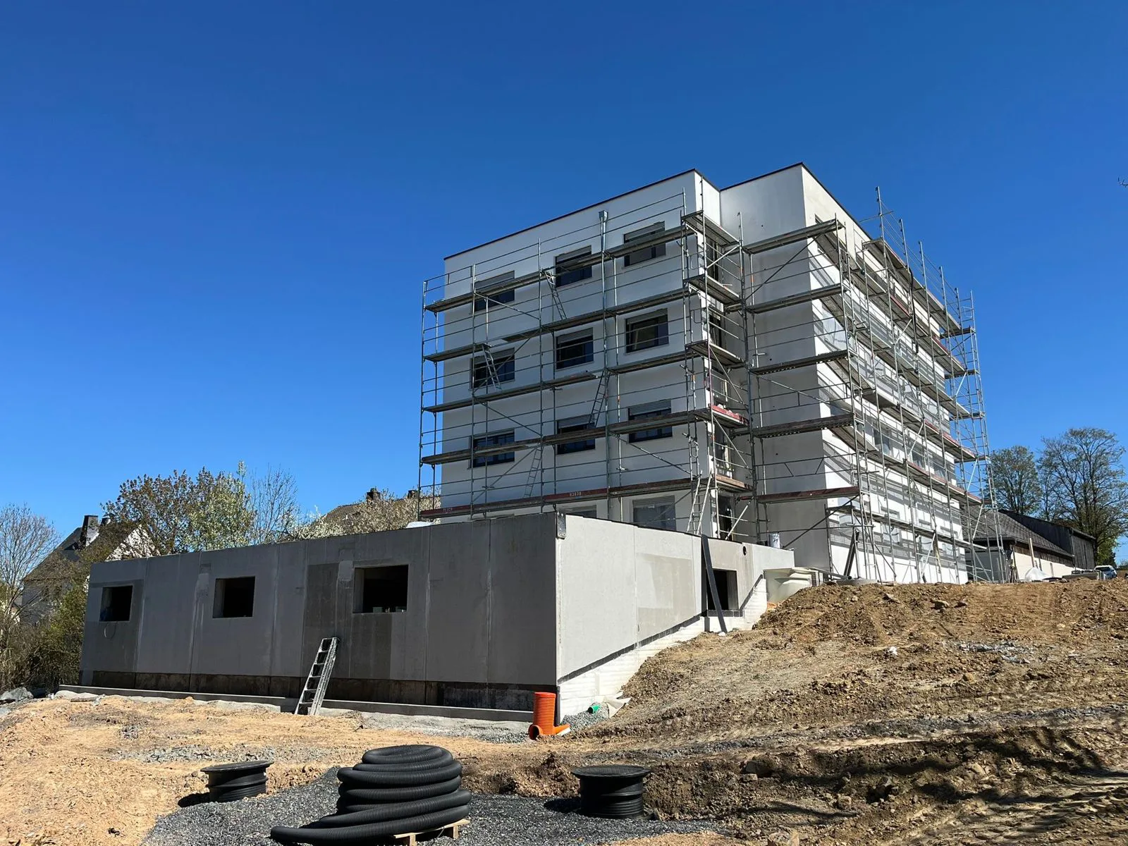 Rohbau mit Gerüst und Tiefgarage im Vordergrund
