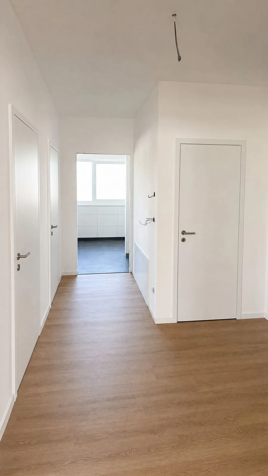 Flur einer Wohnung mit Vinylboden und weißen Türen